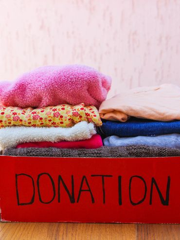 A red box filled with folded clothes labeled 'DONATION'.