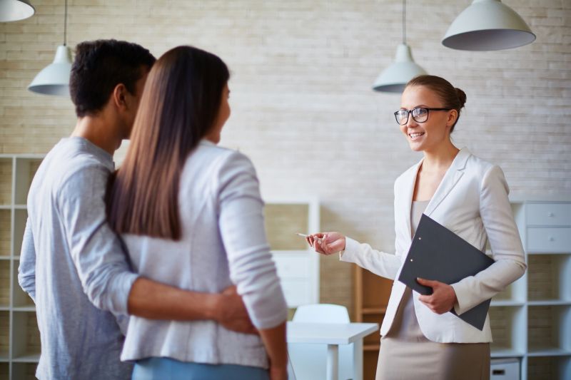 Woman Real Estate Agent talking to a young family