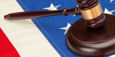 A judge's gavel resting on an American flag.