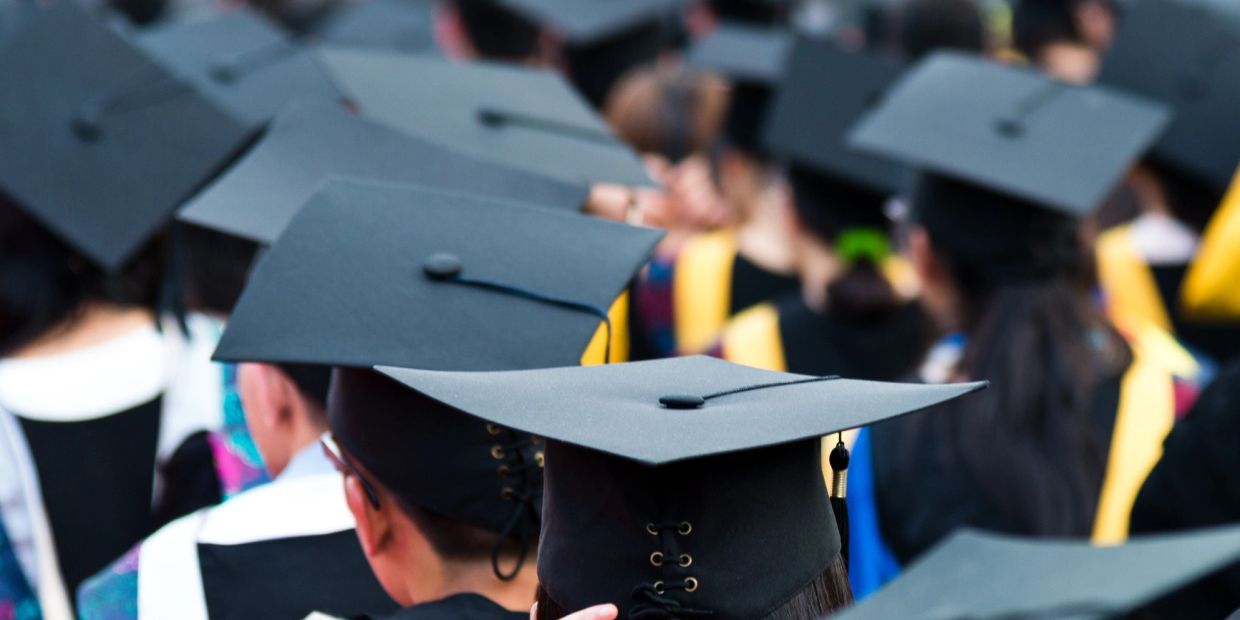 Graduates wearing black caps at a commencement ceremony.