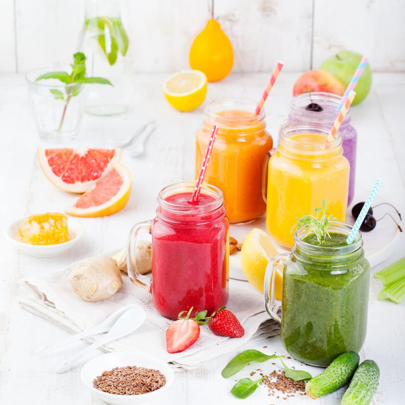 Smoothies, juices, beverages, drinks variety with fresh fruits and berries on a white wooden background.
