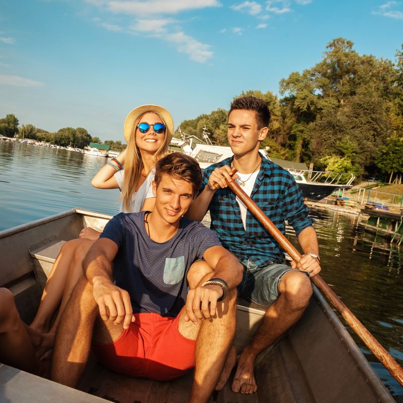 Group Of Young Friends Relaxing On A Boat Enjoying Sunny Day
