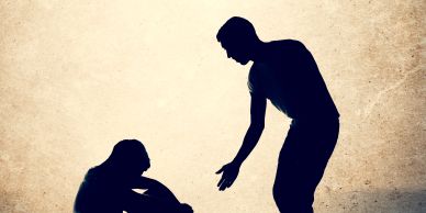 Silhouettes of a person helping another person up.