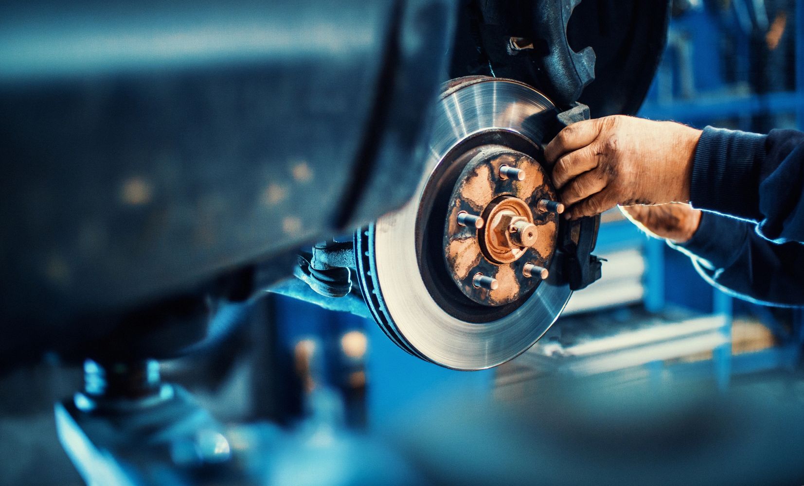 Mechanic installing a brake pad on a car's brake disc.