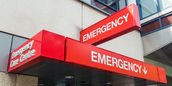 Red emergency signs on a building corner.