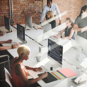 Team collaborating in a modern office space with computers.