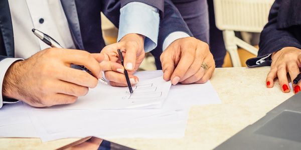 People working together on a document with pens.
