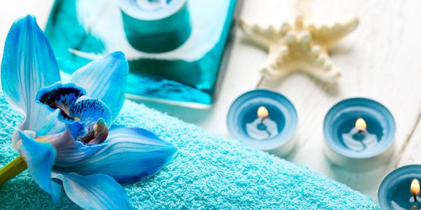 Blue orchid with candles and towel for spa relaxation.