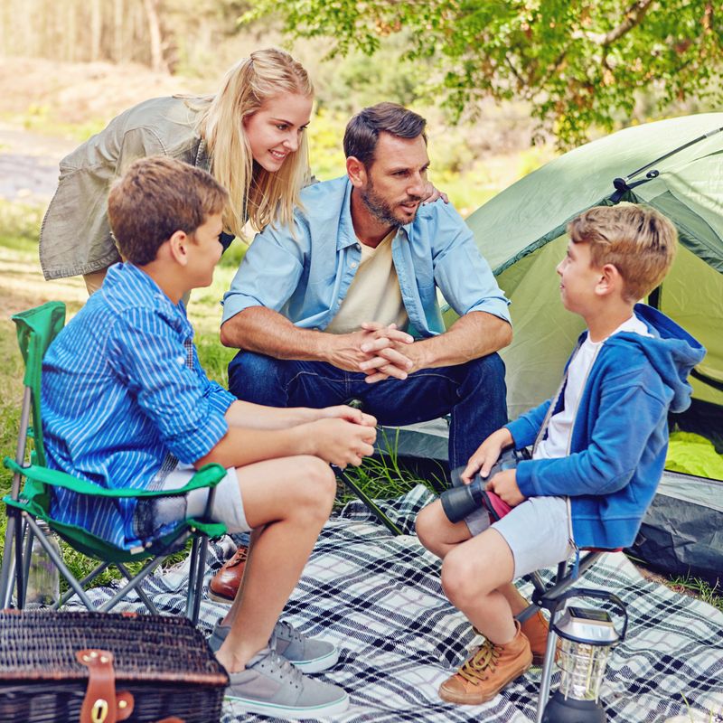 Shot of a family of four camping in the woods
