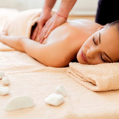 Woman receiving a back massage in a serene spa setting.