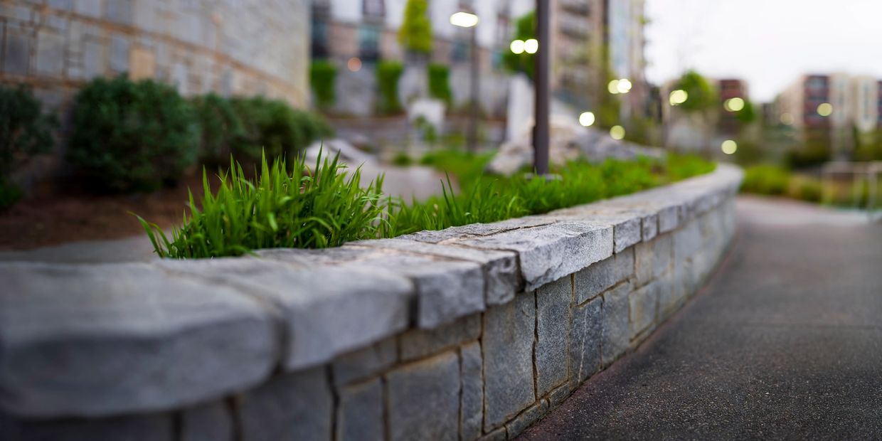 Modern concrete retaining wall installed along a driveway, offering strength, structure, and a polis
