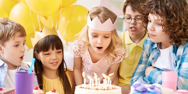 Children celebrating a birthday with cake and balloons.