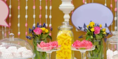 Colorful candy and flower display with decorative backdrop.