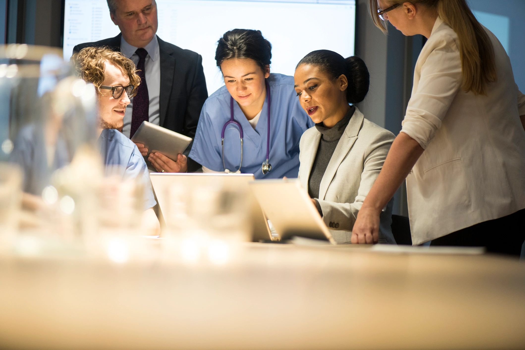 Medical and business professionals collaborating over documents and laptops in meeting. nurses, doctor, collaboration, placement 