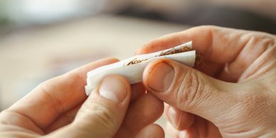 Hands rolling a cigarette.