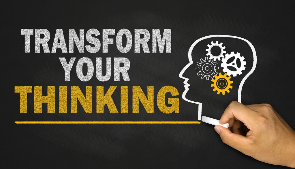 Transform Your Thinking message with gears inside a human head on blackboard.