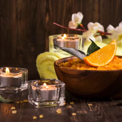 Spa setup with orange slice, candles, and towel.