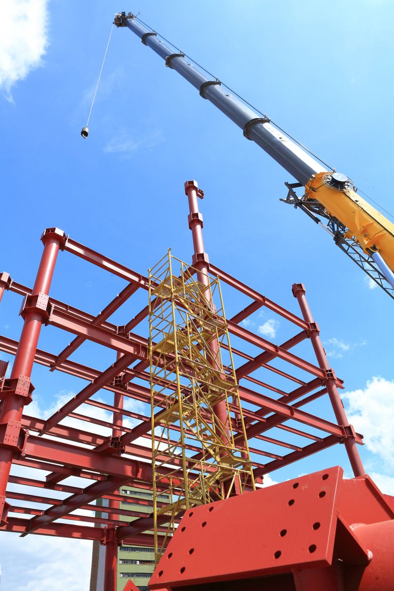 Crane and tubular steel colums already in place and at a steel construction site
