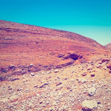 Rocky desert landscape under a clear blue sky.