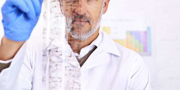 Scientist examining a transparent DNA model in a lab.