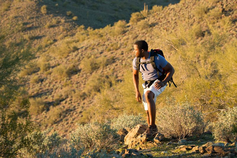 Young man hiking outdoors on a trail at Phoenix Sonoran Preserve in Phoenix, Arizona.