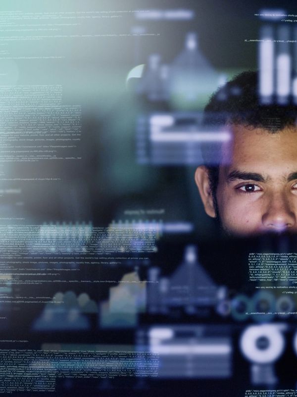 Focused man analyzing digital data and graphs on a transparent screen.