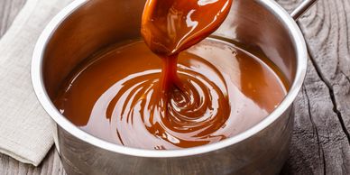 Thick, melted caramel sauce in a pot.