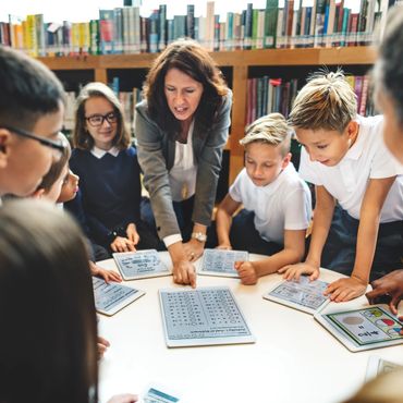Teacher engaging students with interactive learning activities in a library.