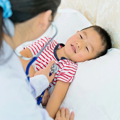 A doctor uses a stethoscope to check a young boy's heartbeat.