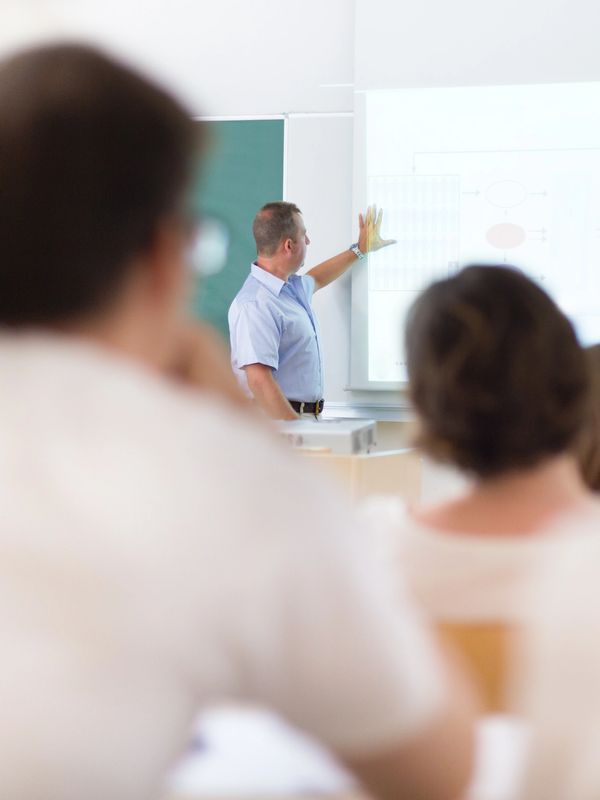 Teacher explaining a presentation to students in a classroom.