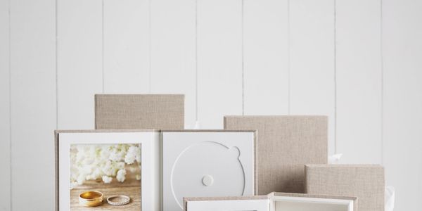 Elegant beige wedding album with rings photo and linen covers.