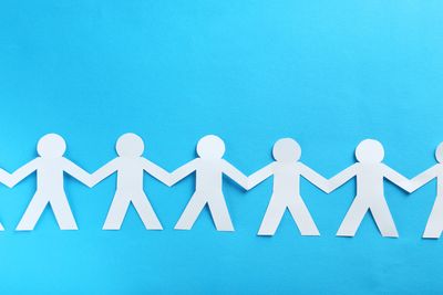A paper cutout showing a chain of humans holding hands