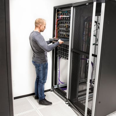 Technician installing a server in a data center rack.