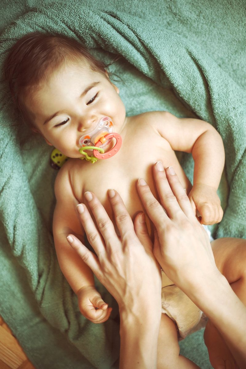 Mother massaging her little baby girl, shallow focus