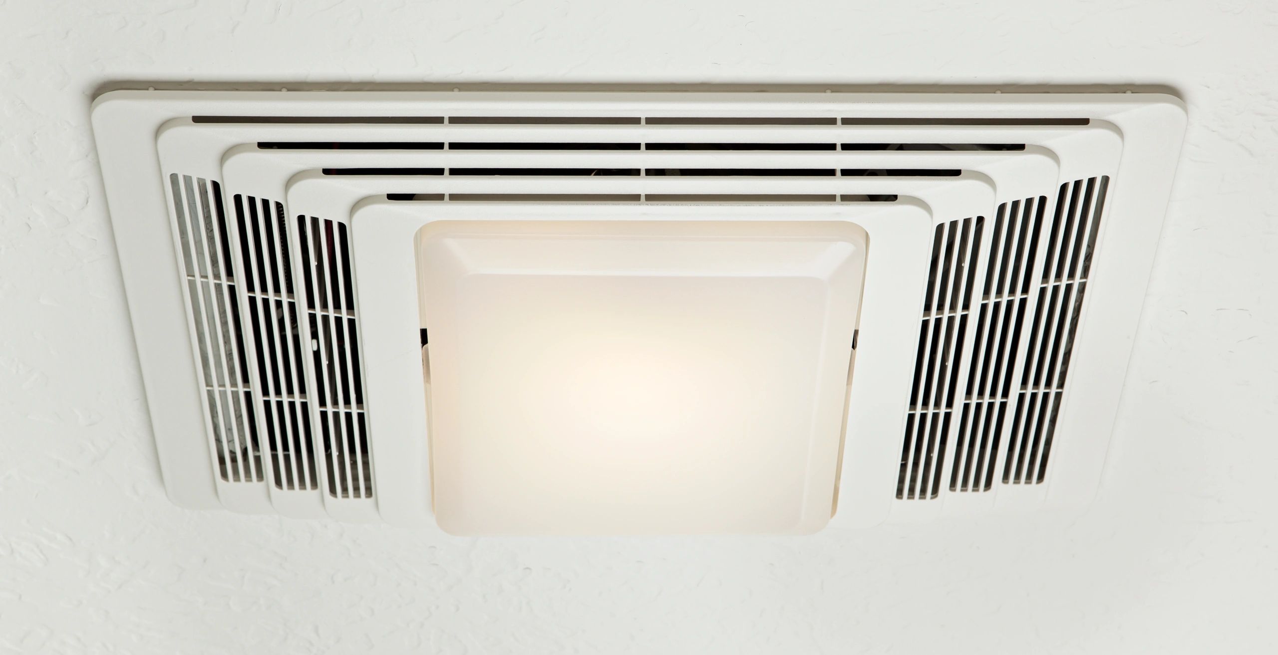 Ceiling-mounted ventilation fan with integrated light fixture.
