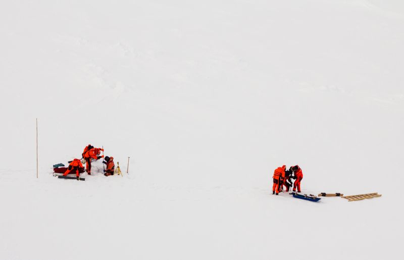 A groÄ±up of polar scientists working over an ice floe in the polar seas