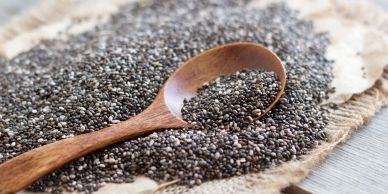 Wooden spoon with chia seeds on cloth.
