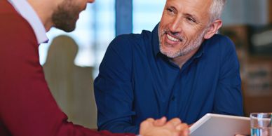 Two men having a friendly business discussion in an office setting.