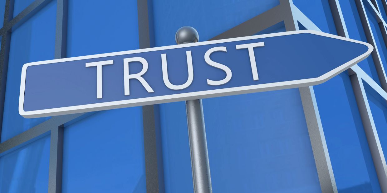 A blue sign that reads "Trust"
