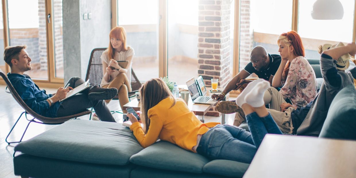Group of young people working and relaxing in a casual office setting.