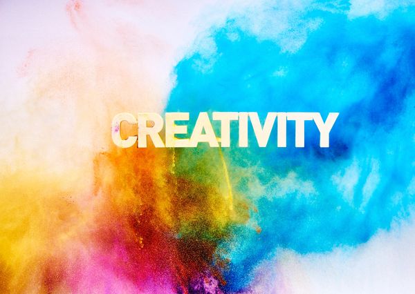 The word 'CREATIVITY' with colorful powder bursts in the background.