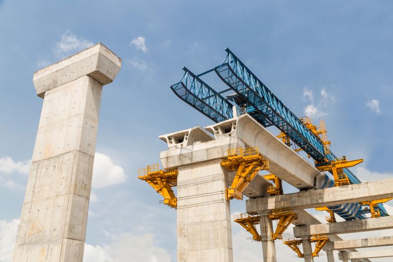 Construction of a mass transit train line in progress with heavy infrastructure.  This photo shows the progress in joining the various blocks/modules of the line with heavy equipment.