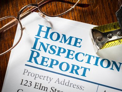 Home inspection report with glasses and tape measure.