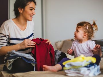 Parent prepping and tagging clothes for consignors at Cola Kids