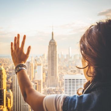 Persona saludando a la ciudad de Nueva York desde un mirador.