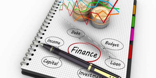 Notebook with finance-related terms and coins showing financial growth charts.