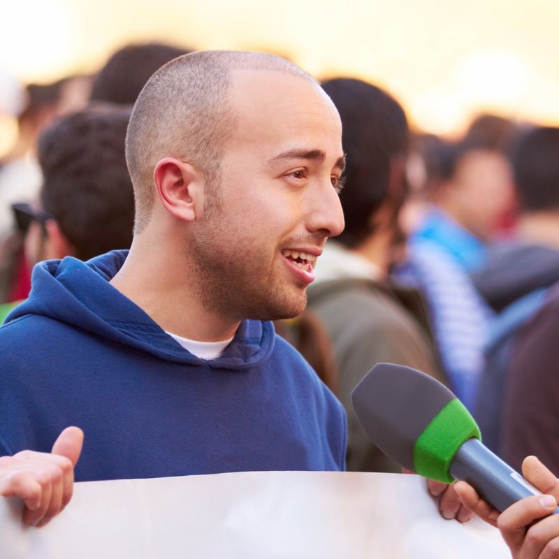 Shot of a protestor being interviewed at a rally