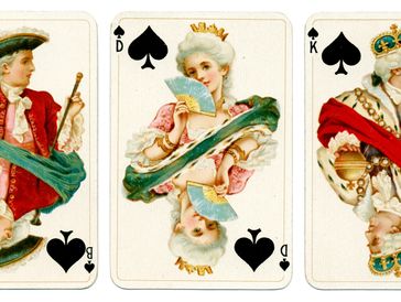 Three vintage playing cards with royal figures from the spade suit.
