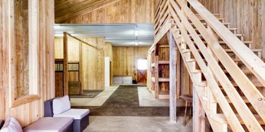 Spacious wooden interior with stairs and cozy seating area.