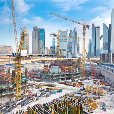 Large construction site with cranes and skyscrapers in the background.